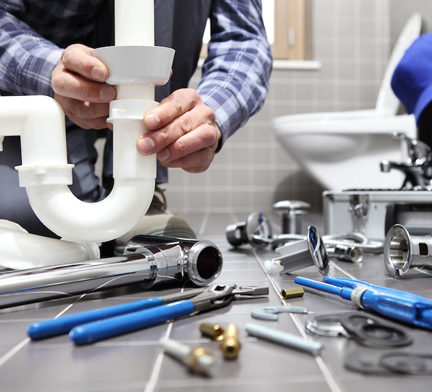plumber installing a new u bend pipe in a bathroom